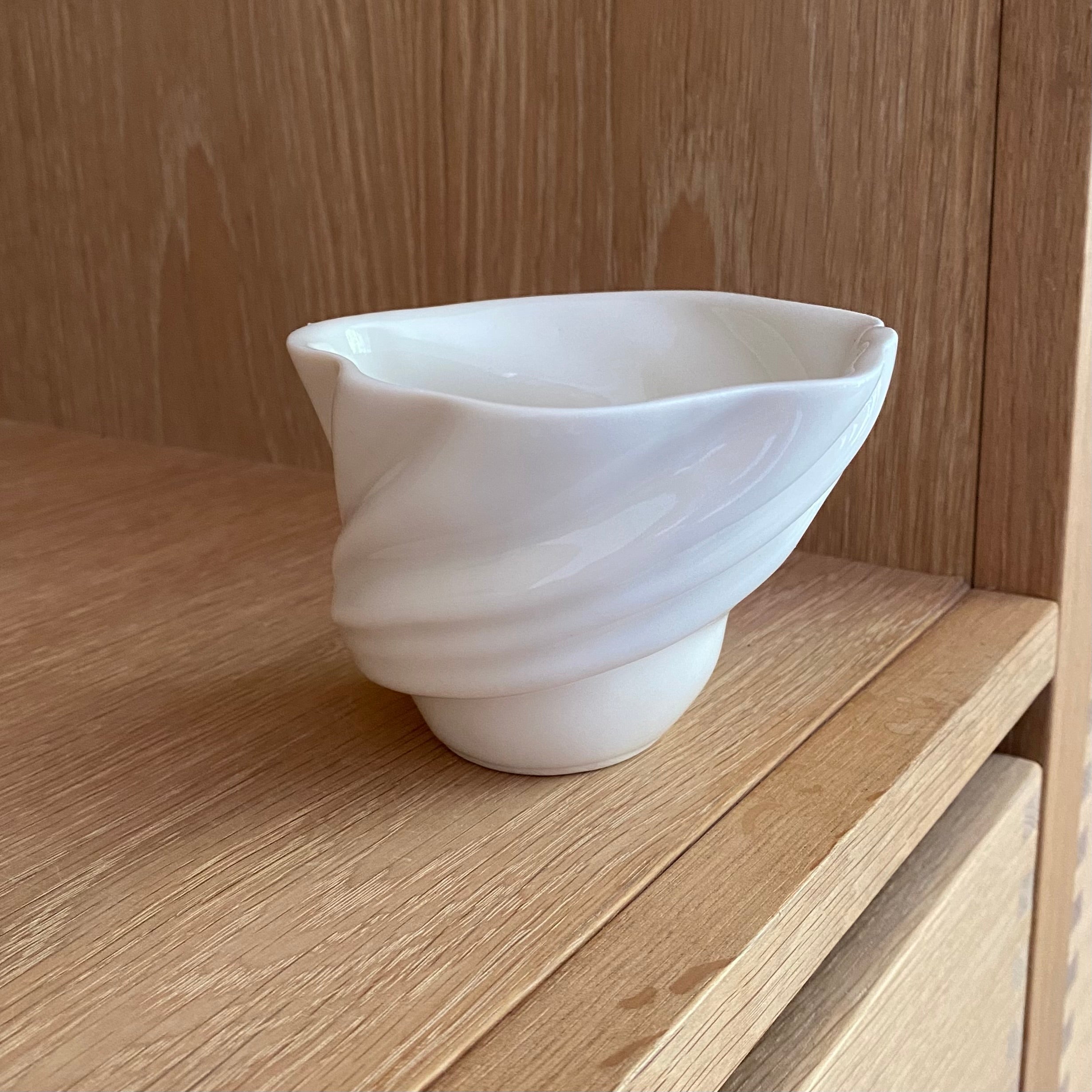 Håndlavet svanekop i porcelæn med riflet overflade – set forfra på træbord