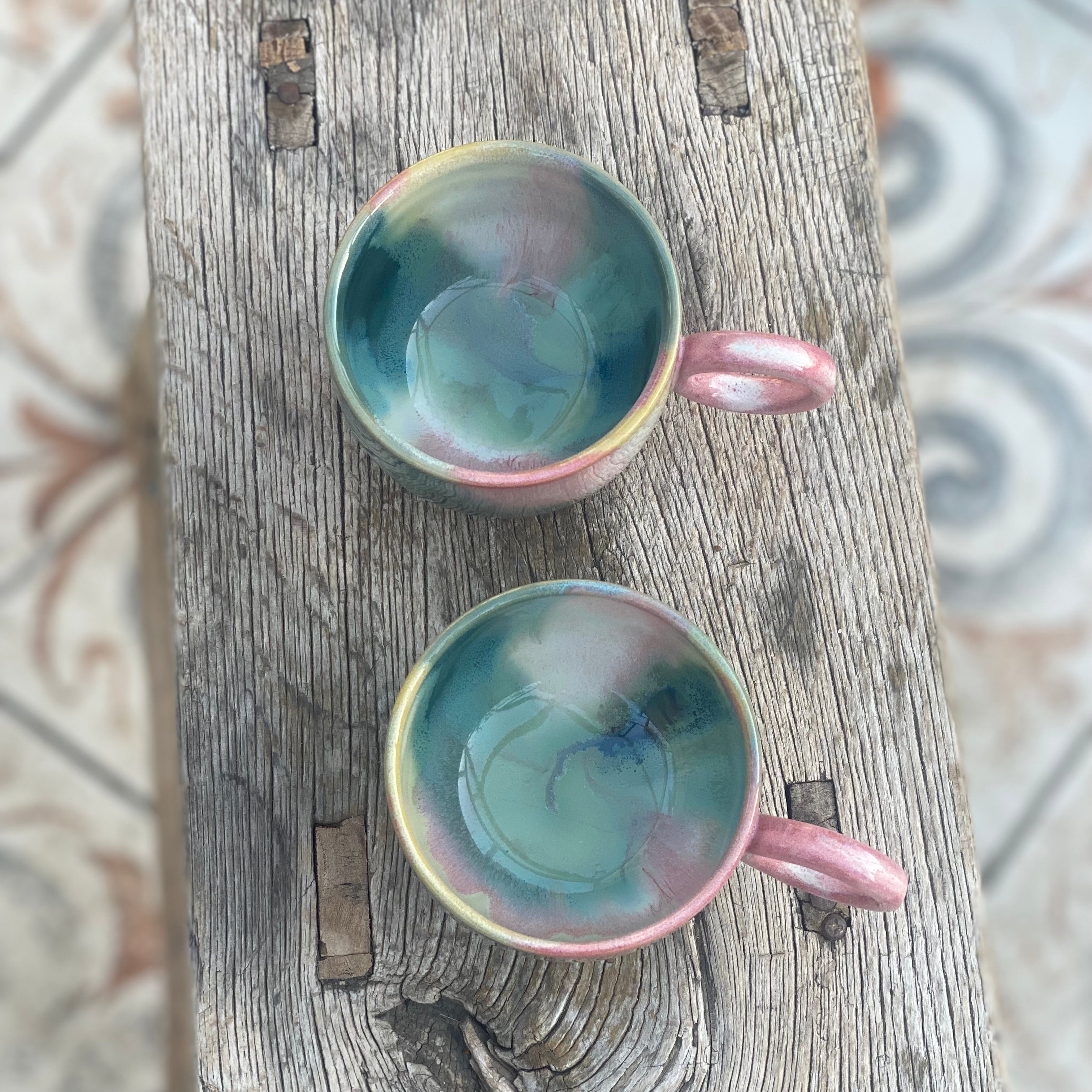 Farverige kopper med hank set oppefra i lyserøde og grønne farver