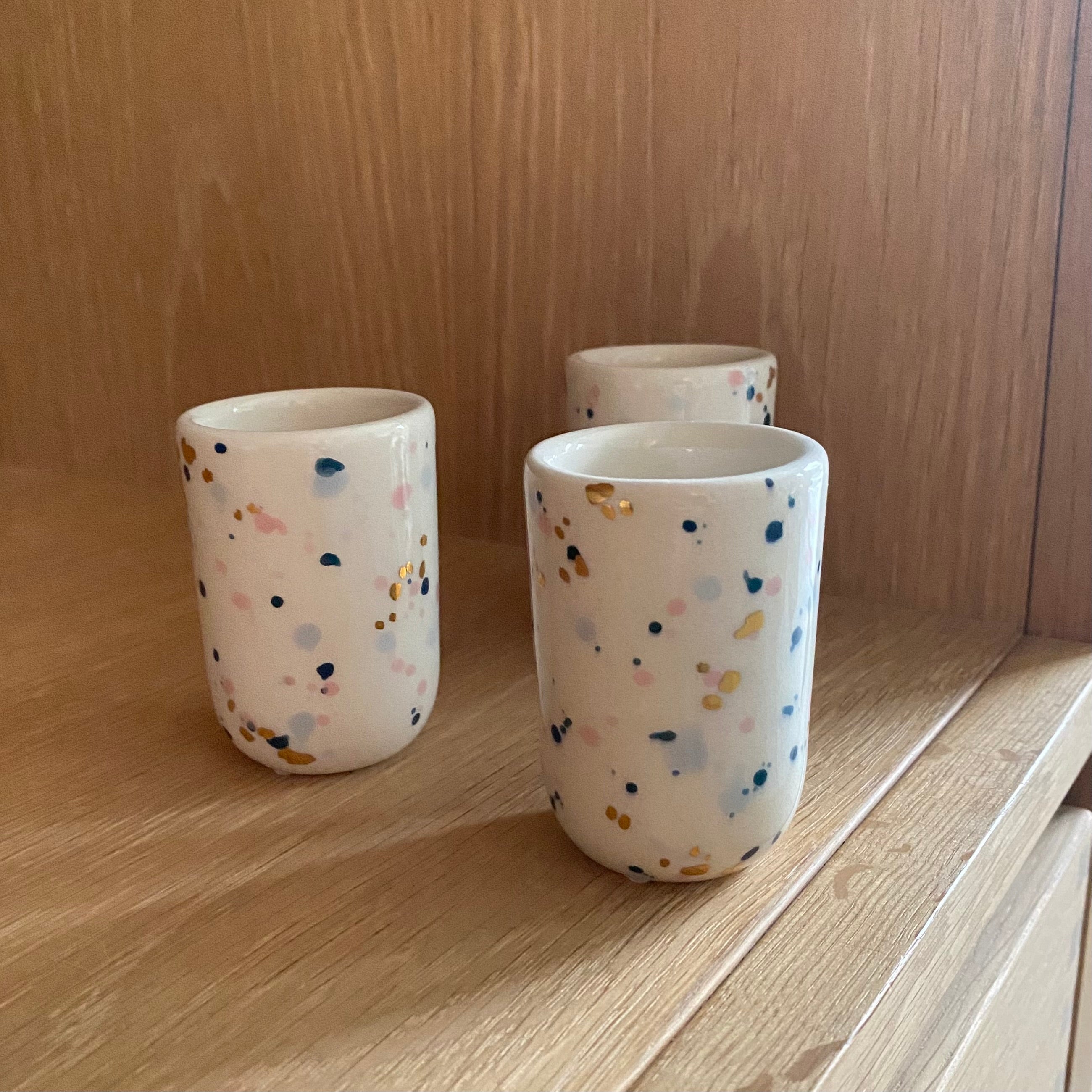 små espressokopper med prikker i blå, guld og lyserød og som ligner konfetti