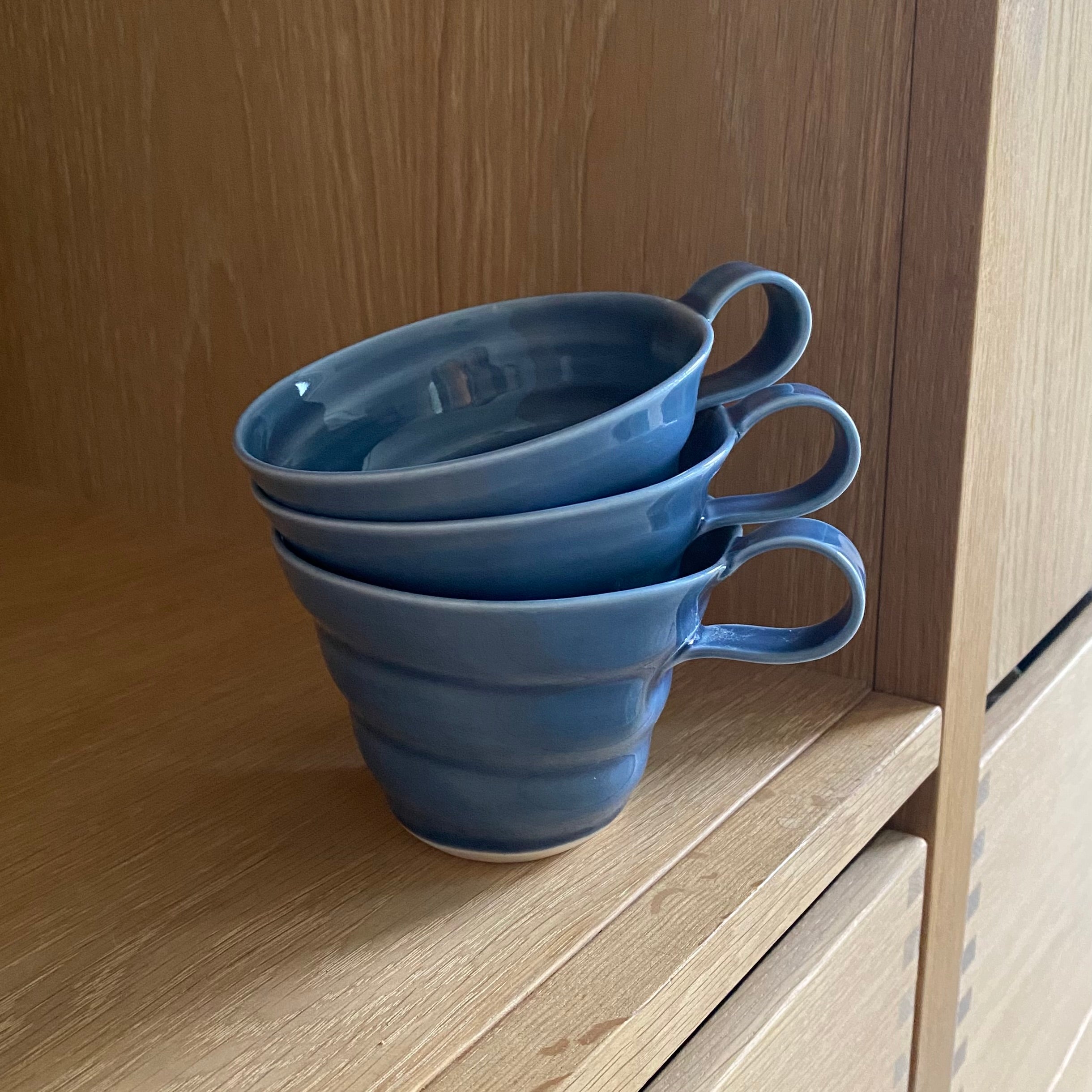 Porcelæn kop med spiralform – i smuk mørk blå nuance – drejet i hånden af Rikke Mangelsen