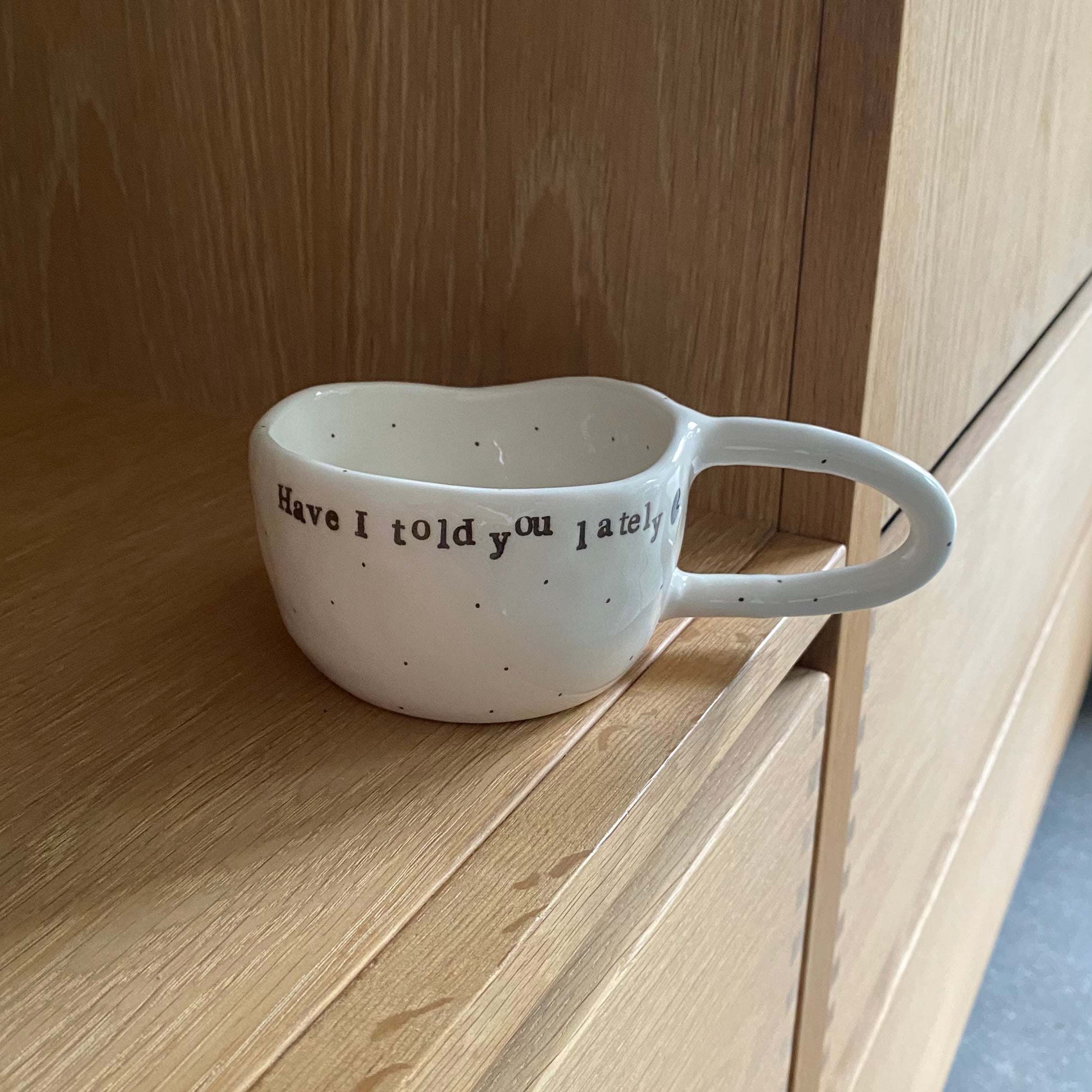 Håndlavet kop med hank og tekst “Have I told you lately” i hvid keramik med sorte prikker