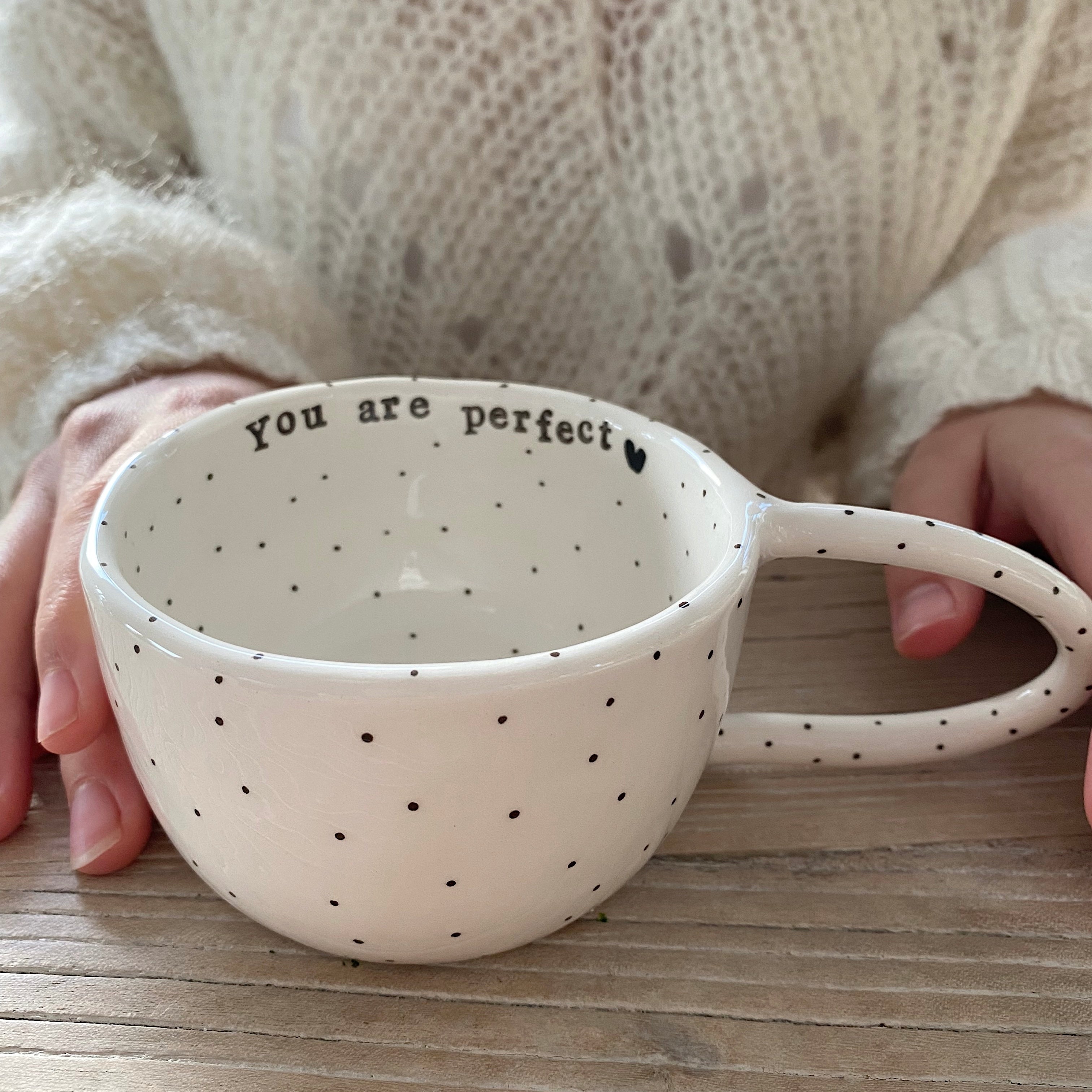 Håndlavet kop med hank og teksten “You are perfect” i hvid keramik med sorte prikker