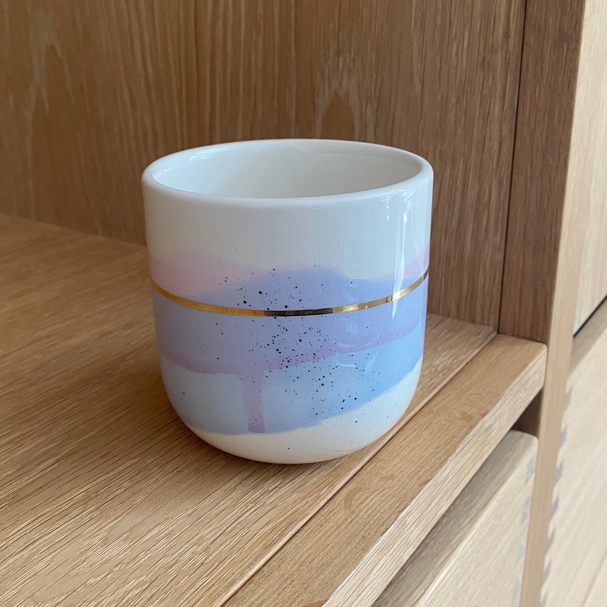 Håndlavet lattekop i blå og lilla farver og med guldstreg rundt om koppen