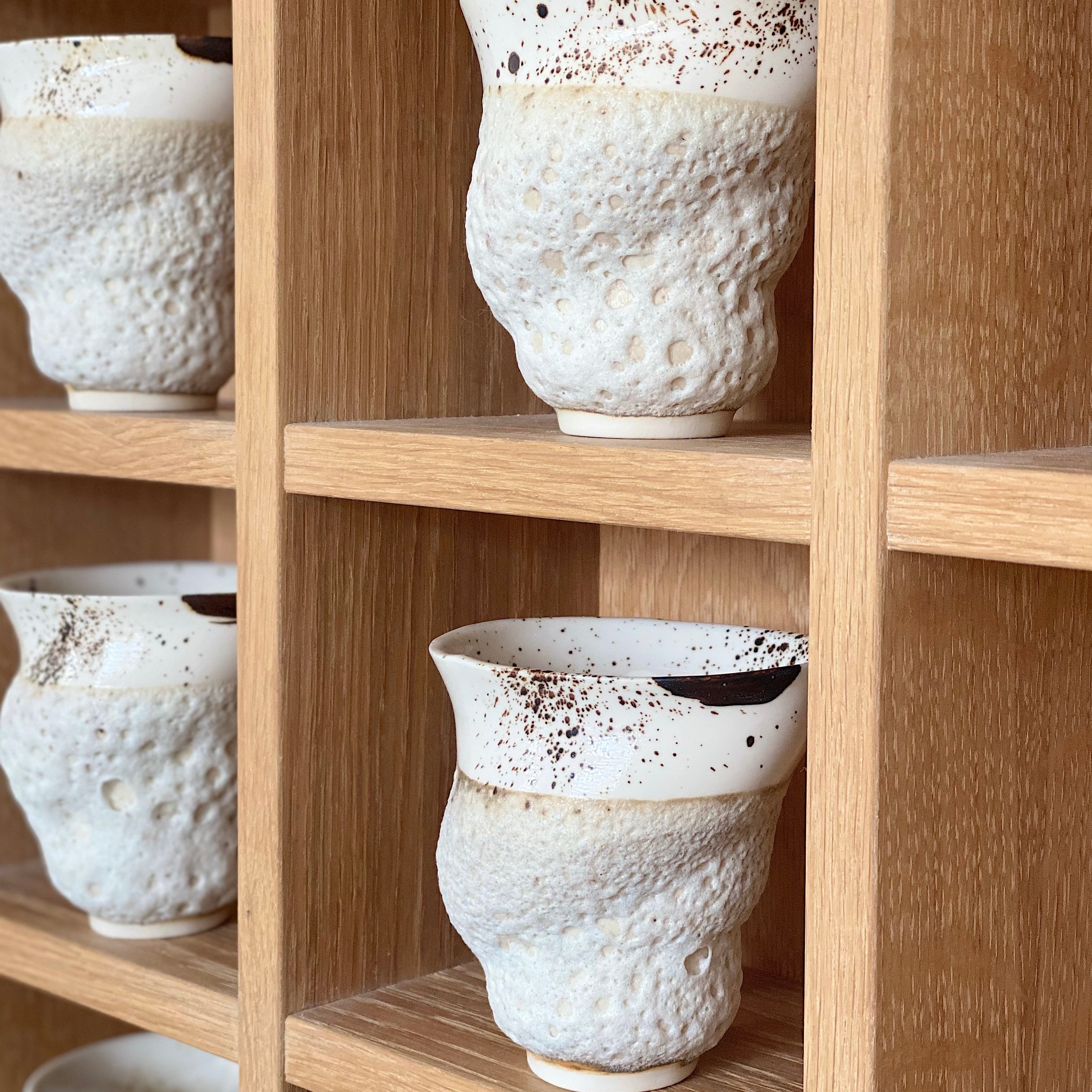 Håndlavede Marsk kaffekopper fra Studio Aarhus stående på hylde – brun og beige keramik med unik glasur