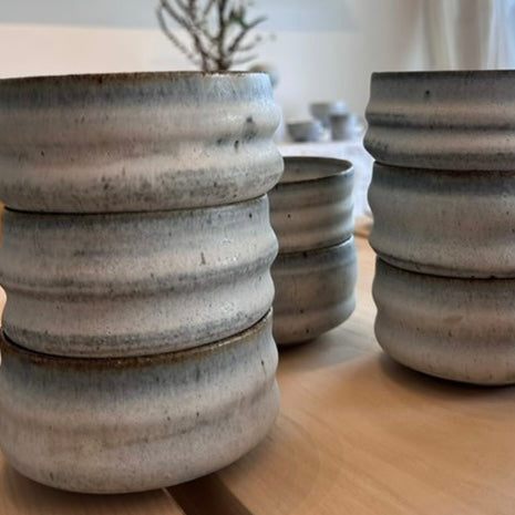 Detalje af matcha kop i mat hvid og blågrå keramik – hånddrejet struktur og levende glasur.