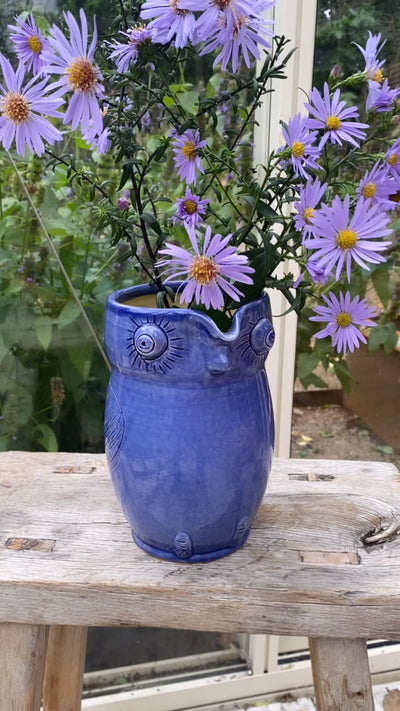 Blå uglekande brugt som vase med lilla asters – håndlavet dansk keramik fra unika:k