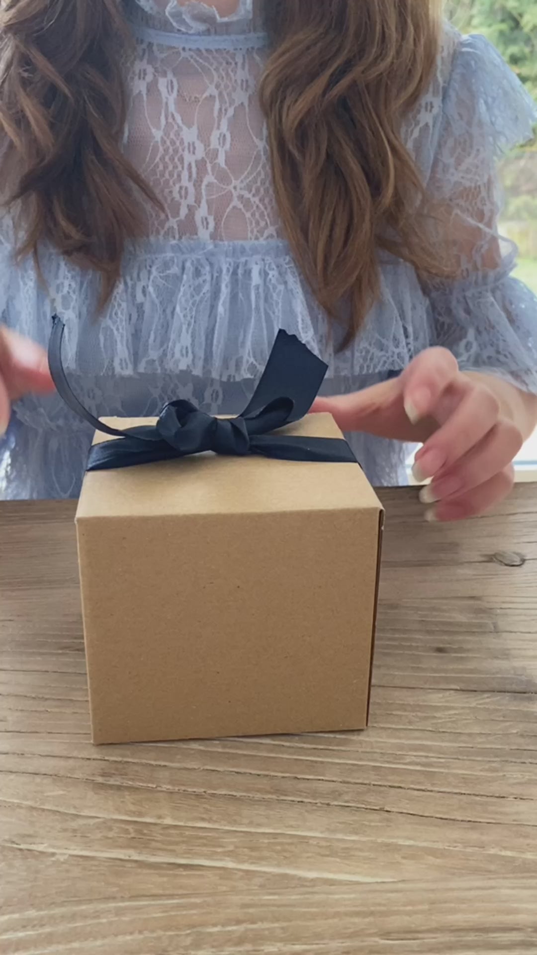 en gave med en hånddrejet riflet kop i blågrå keramik der pakkes op