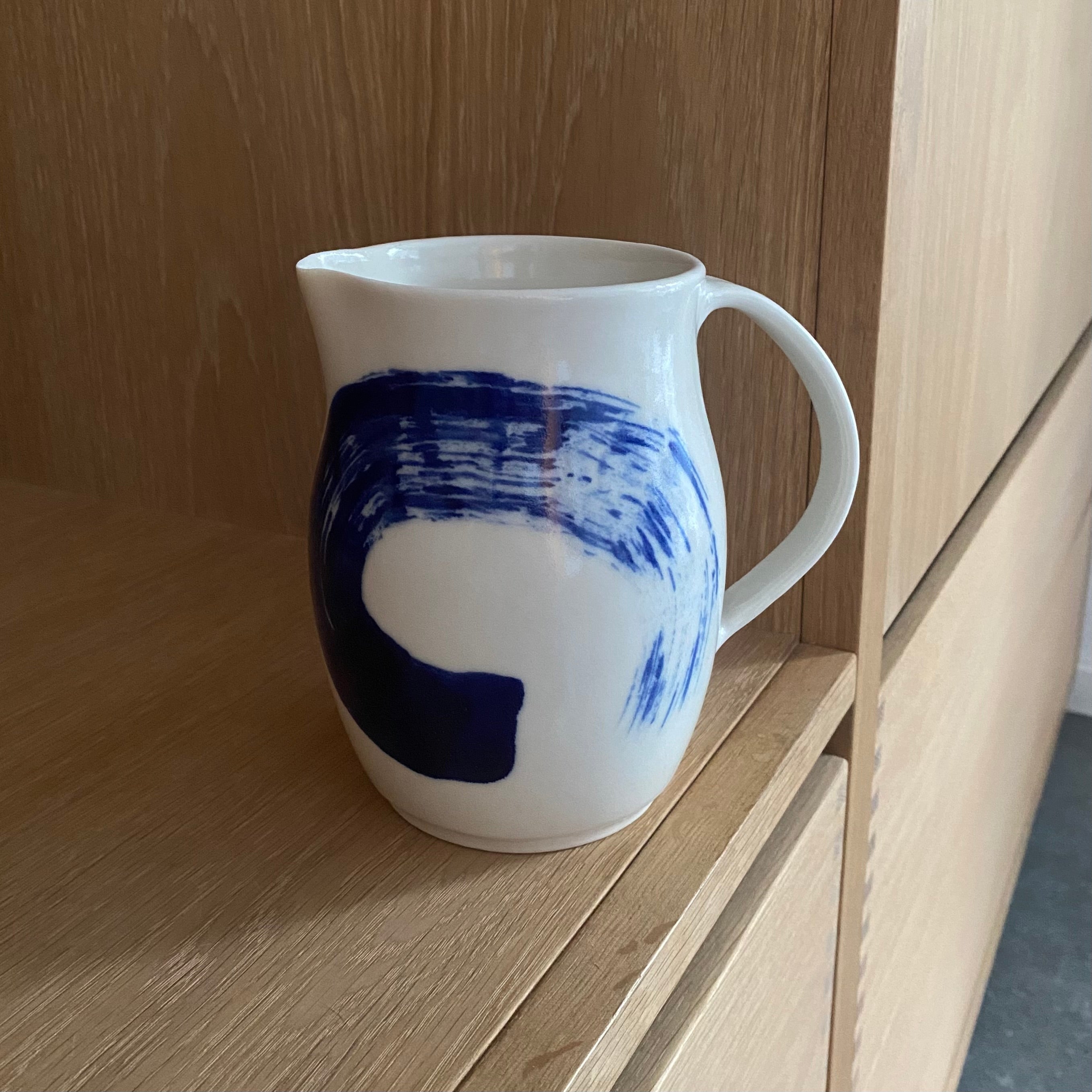 Stor hånddrejet kande i porcelæn med blå bølge – designet af Ann-Louise Roman