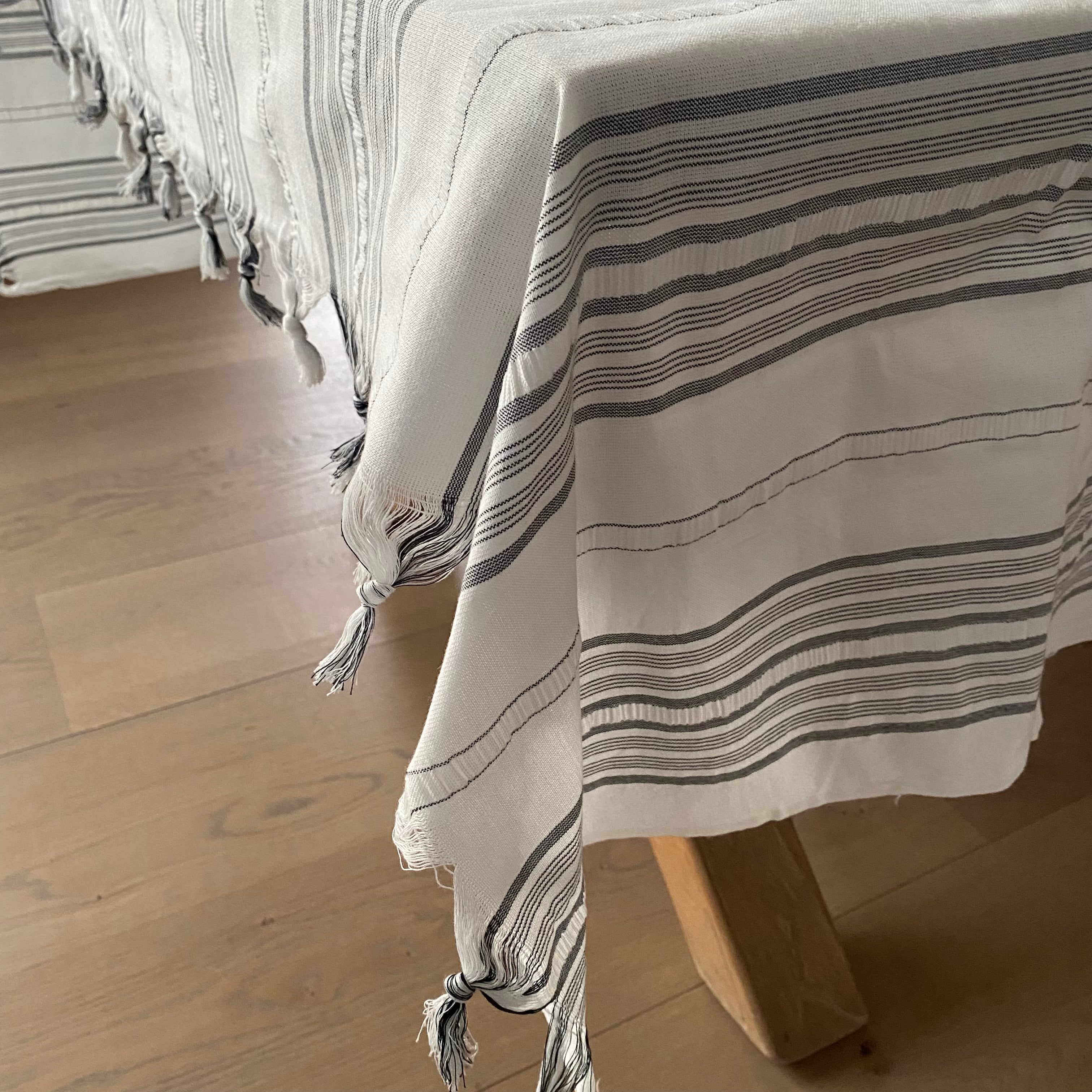 Styling af hvid dug med gråsorte striber på spisebord