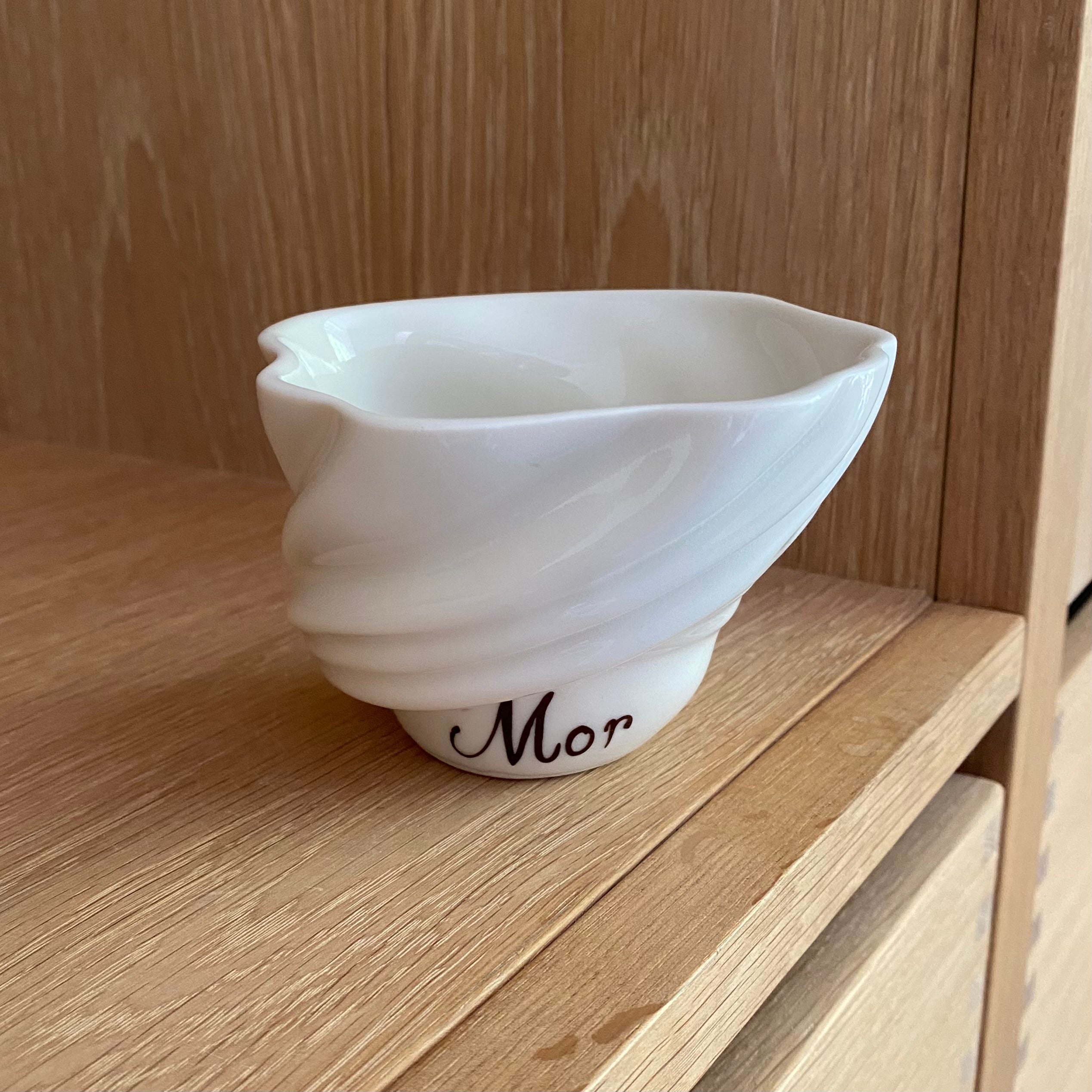 Håndlavet svanekop i blankt porcelæn med teksten ‘Mor’ – set forfra på bord