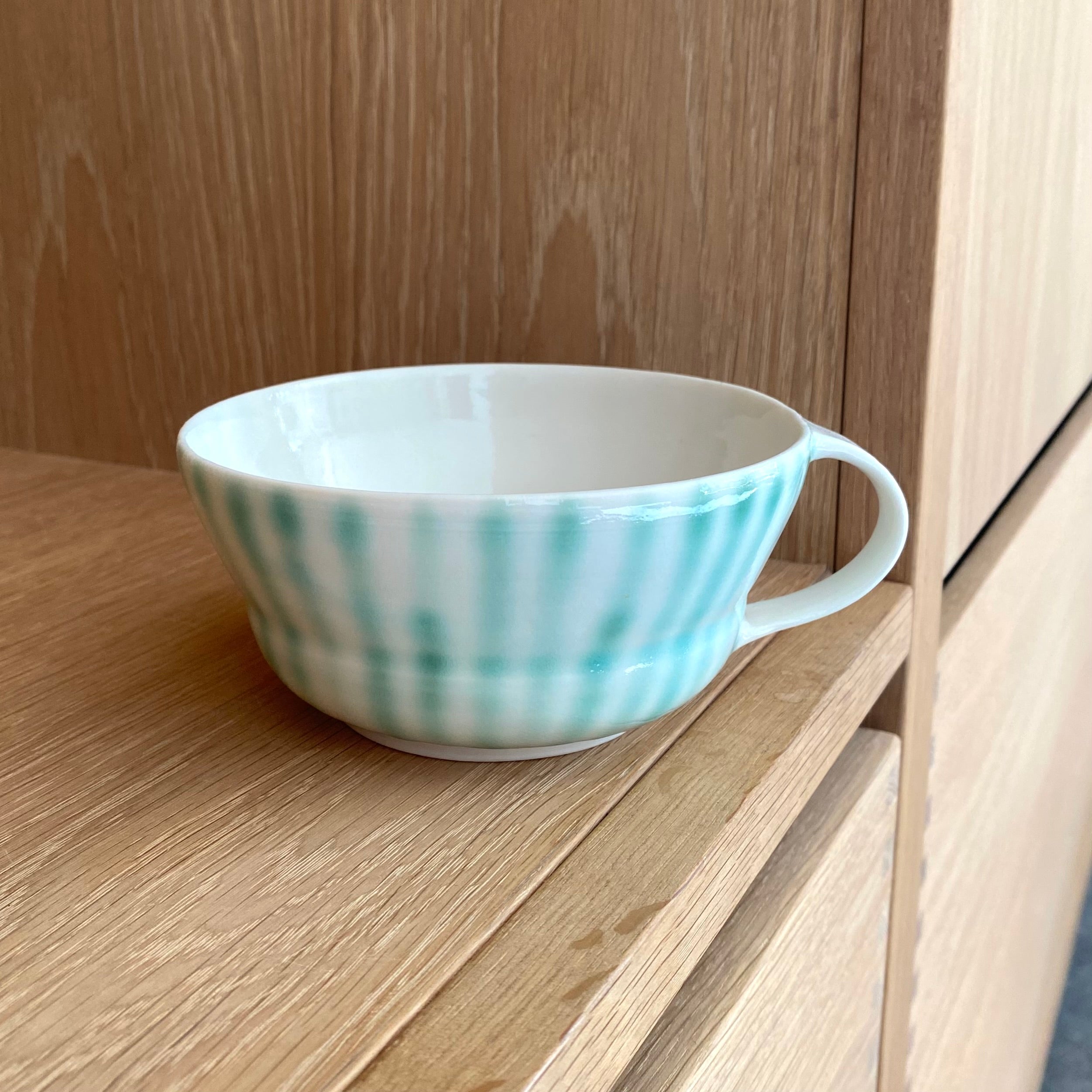 Hånddrejet porcelænskop med grønne striber fra Ann-Louise Roman.